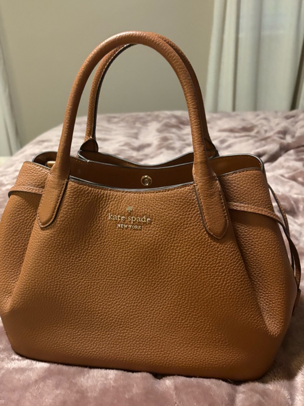 kate spade brown large dumpling bag with gold logo and cross body strap.